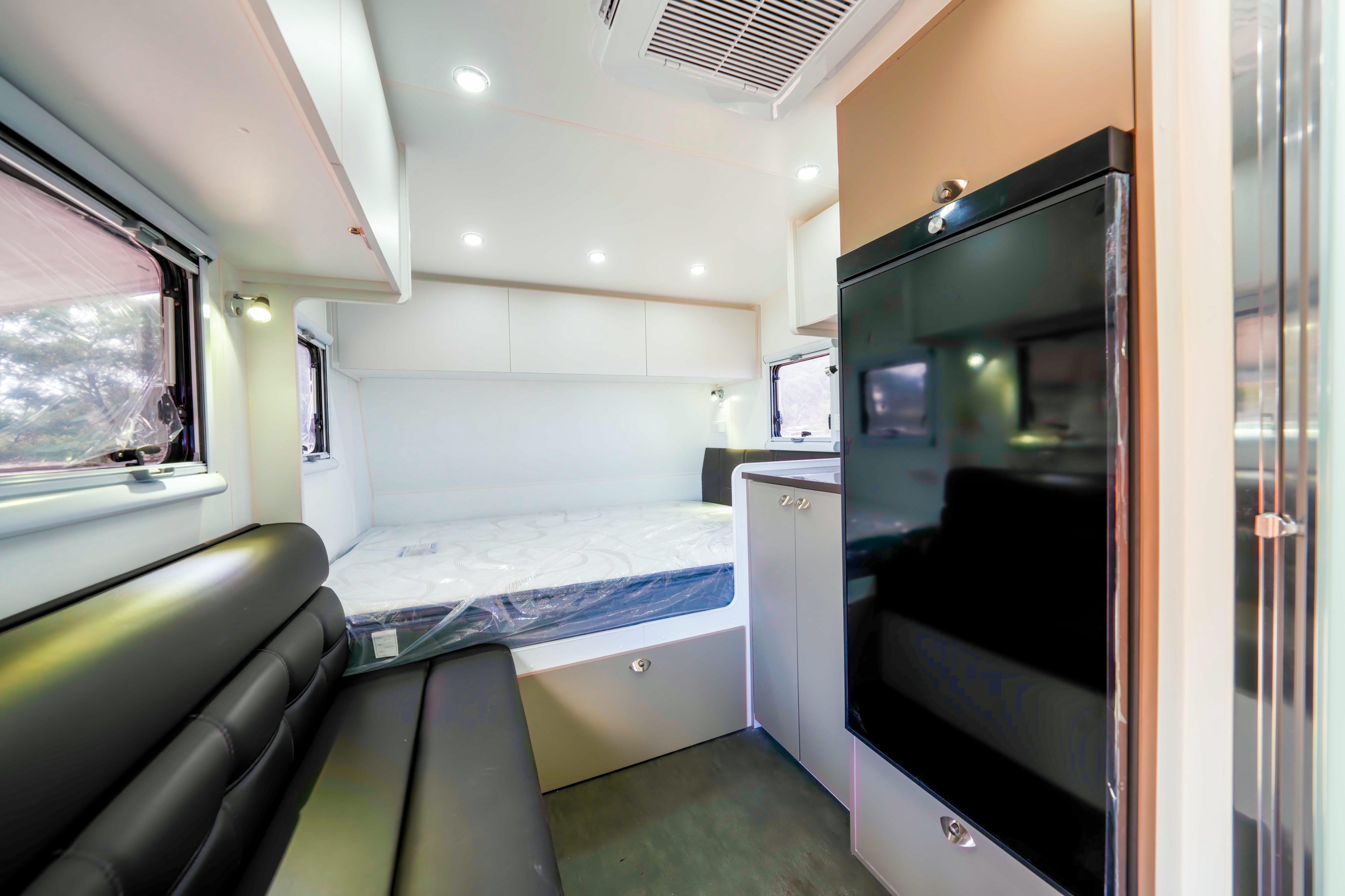 Pro RV Caravans Dingo Caravan living area with fridge, bed and drawers.
