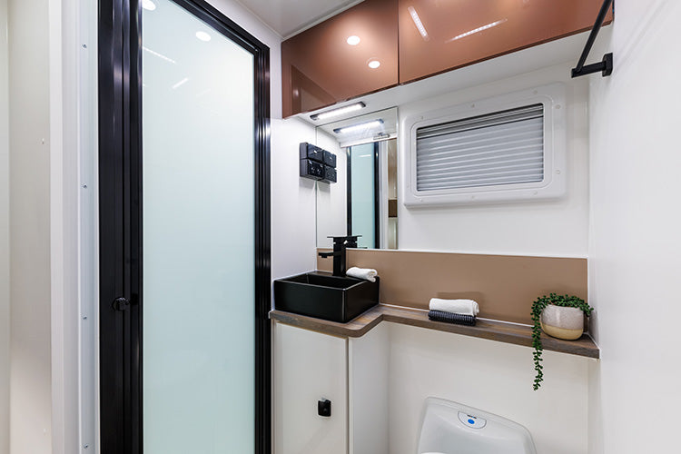 ProRV Falcon Angle Kitchen Cravan Interior Toilet Including Tap, Sink, and Cupboards.