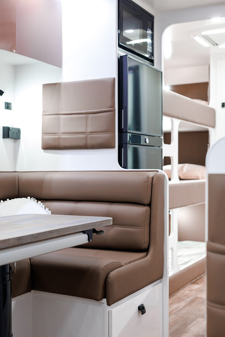 ProRV Falcon Angle Kitchen Caravan Interior Table and Chairs Angled to Include Fridge, Microwave and Bunks.