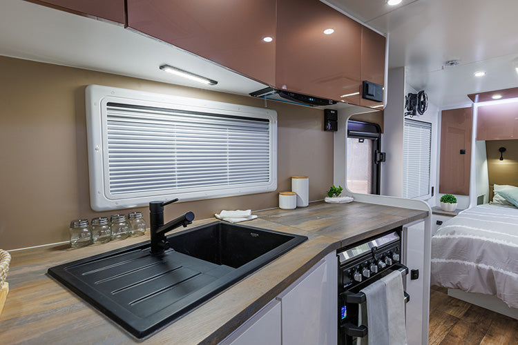 ProRV Falcon Angle Kitchen Caravan Interior Kitchen Including Tap, Sink, Cookware, Cupboards, Drawers, and Oven Angled to Inlcude Bed.
