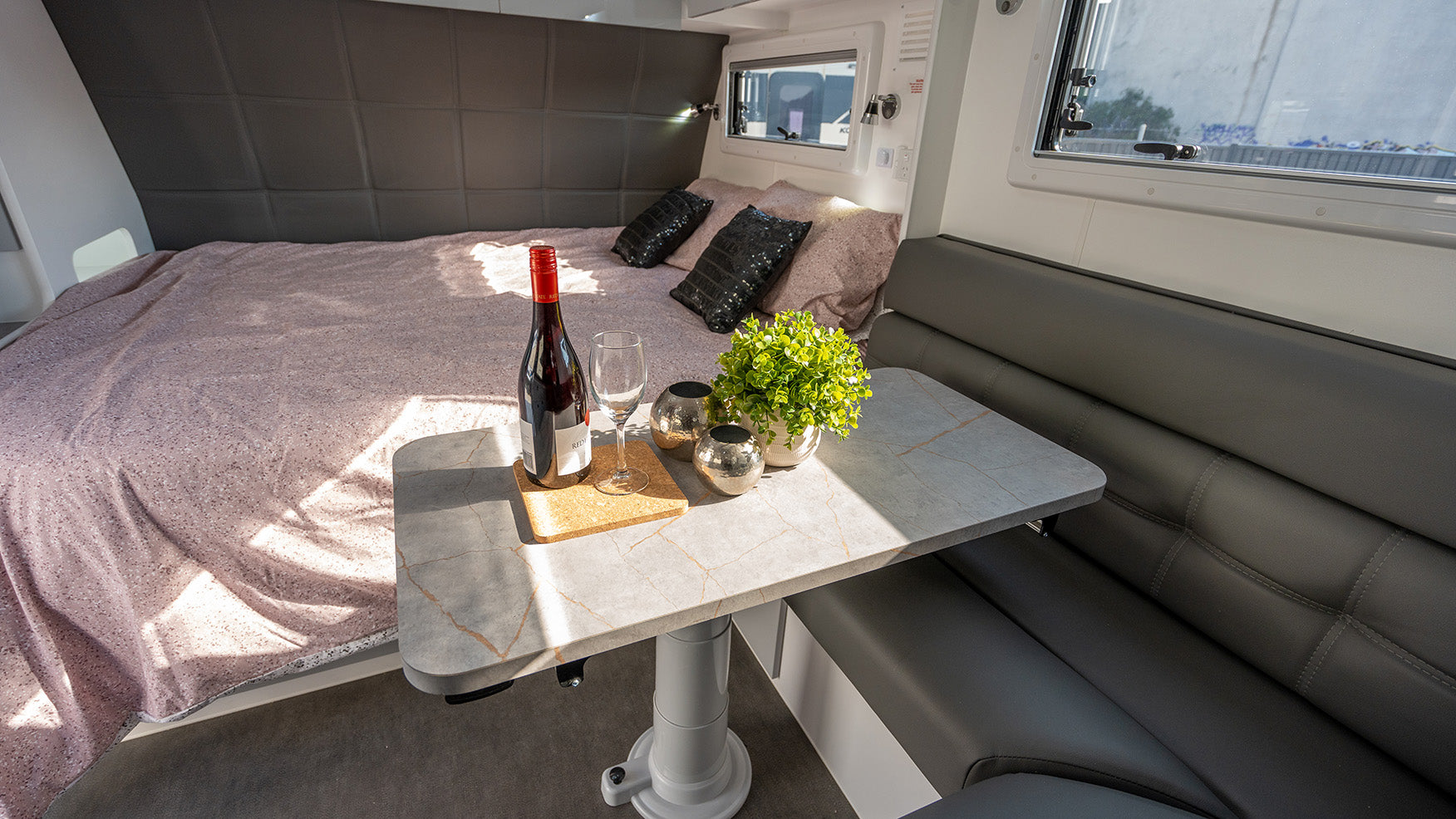 ProRV Family Hawk Caravan Interior Bed Angled to Include Table and Chairs.