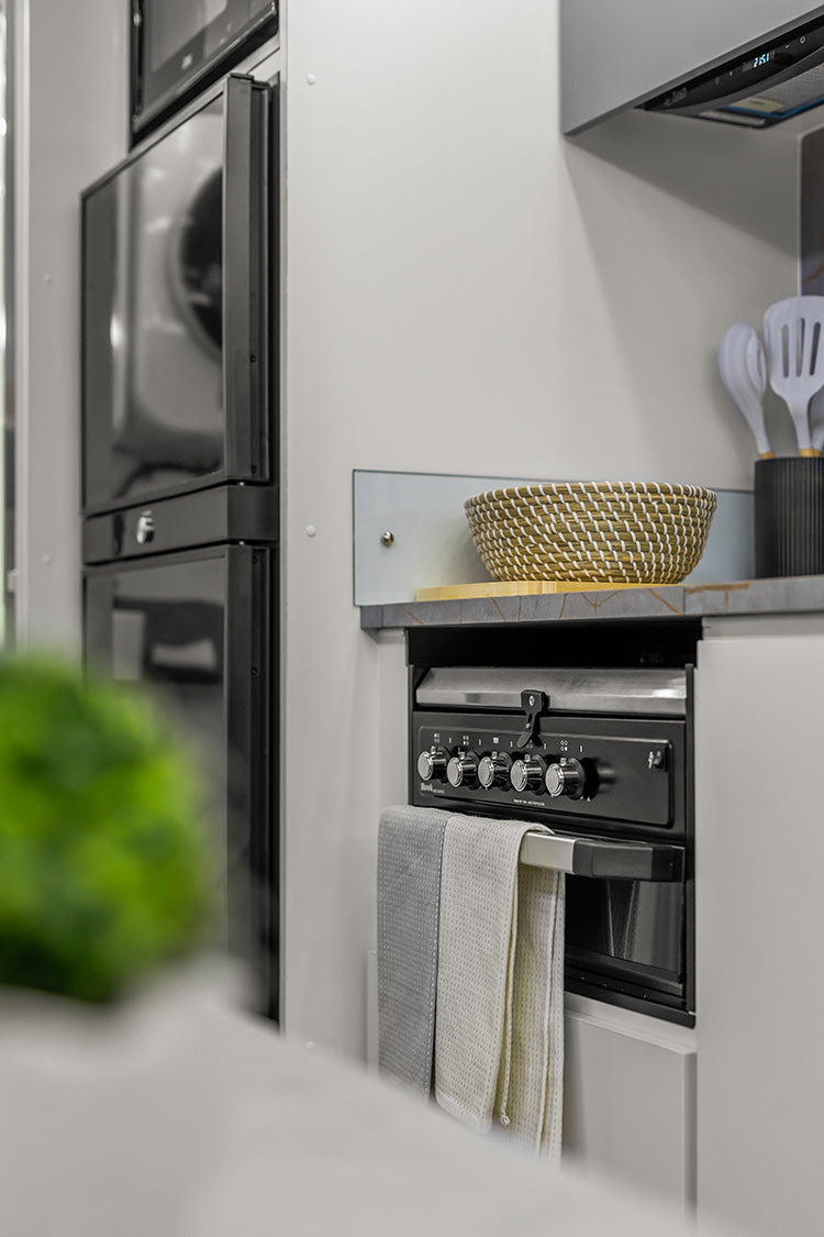 ProRV Family Jaguar Caravan Interior Kitchen Including Oven and Cupboards Angled to Include Fridge and Microwave.