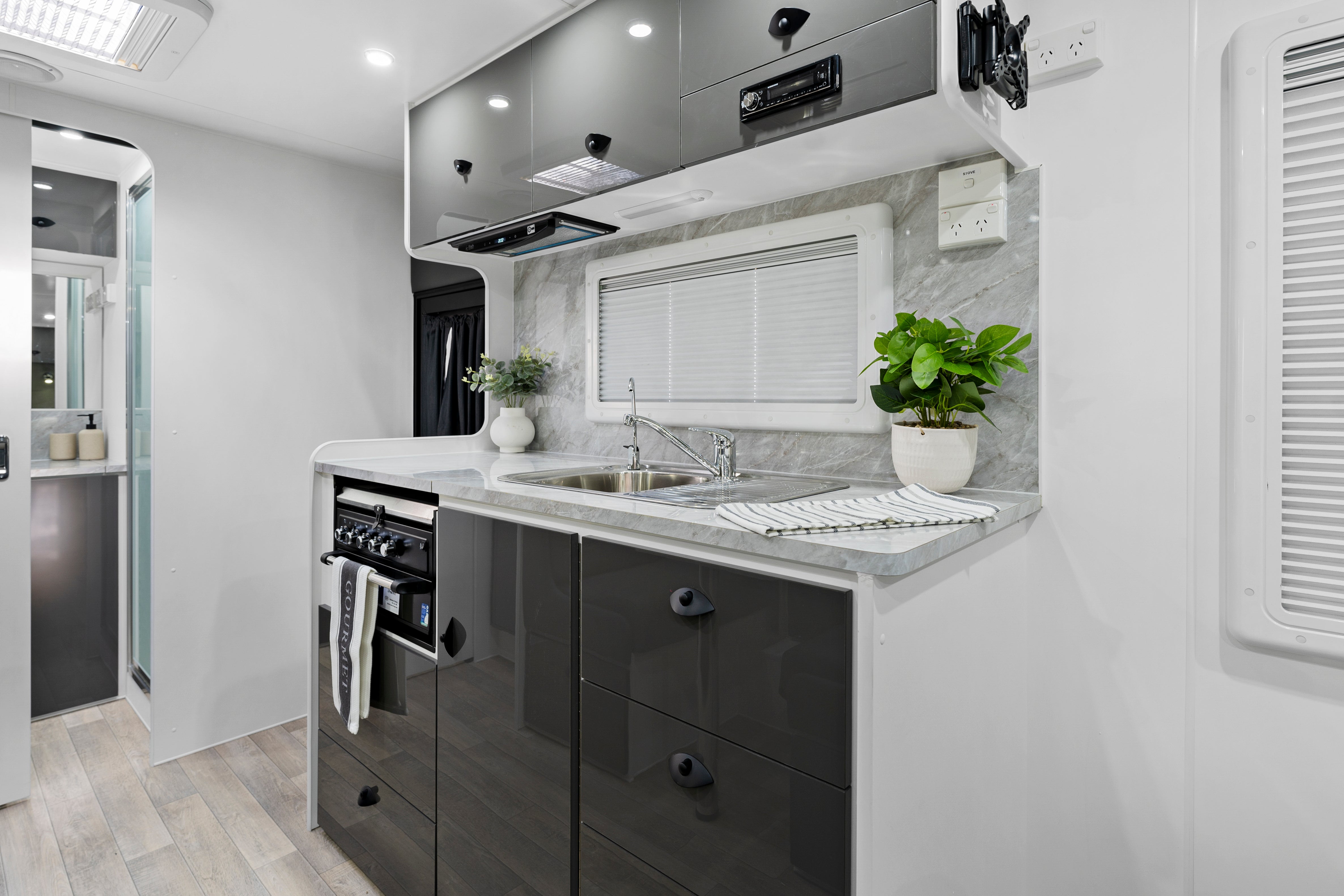 ProRV Jaguar Caravan Interior Kitchen Including Tap, Sink, Covered Cooktop, Cupboards, Drawers, and Oven.