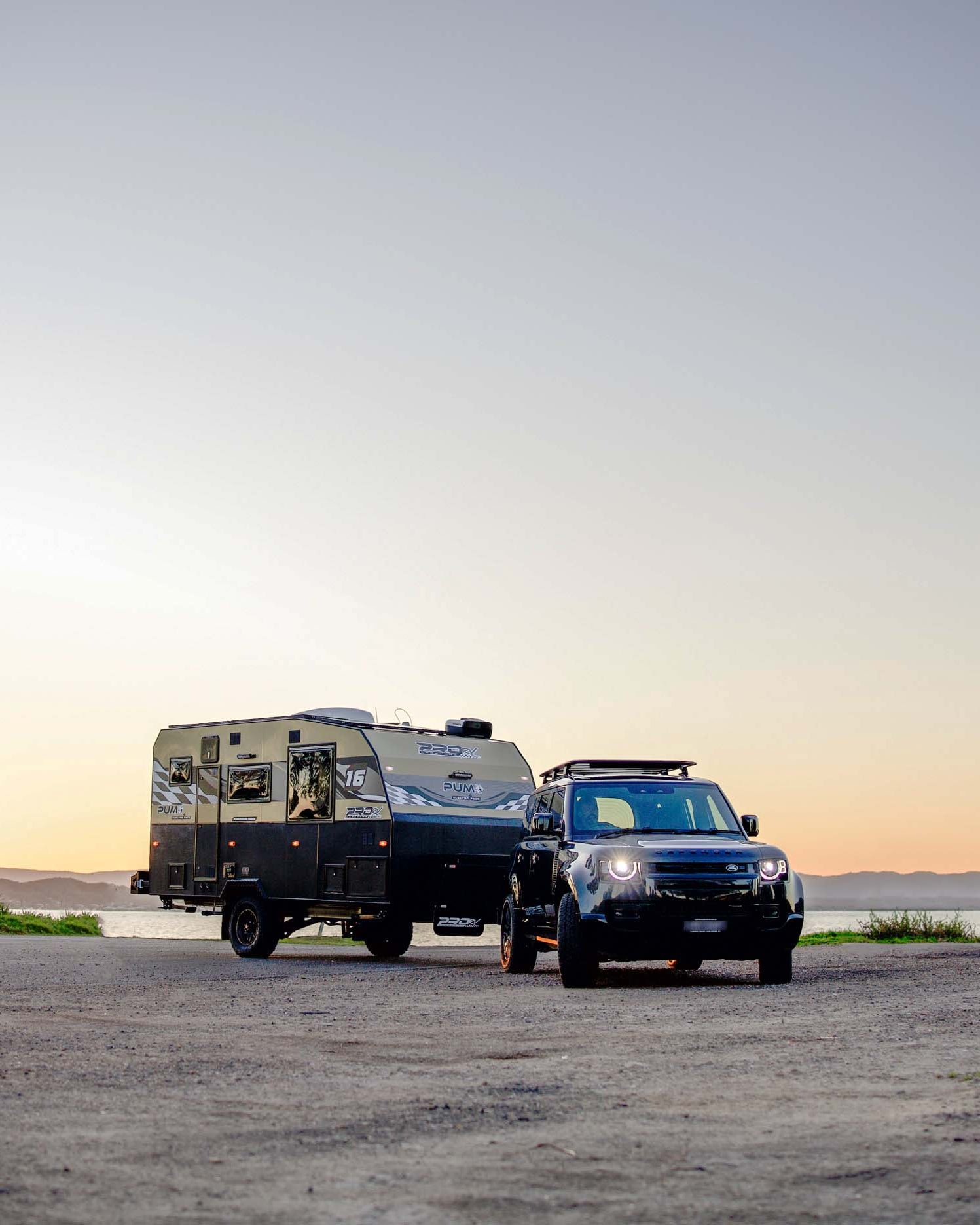 PRORV Caravans Puma caravan attached to a utility vehicle on a beach.