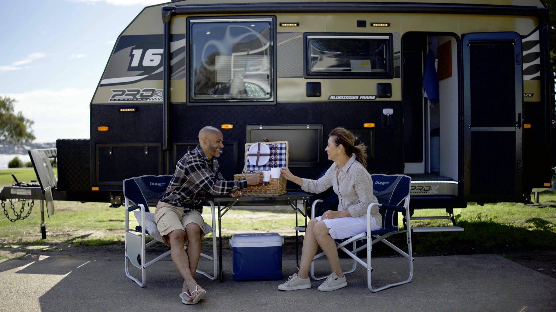 Couple sitting in font of ProRV Caravans Puma caravan.